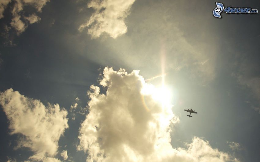 słońce za chmurami, samolot na niebie