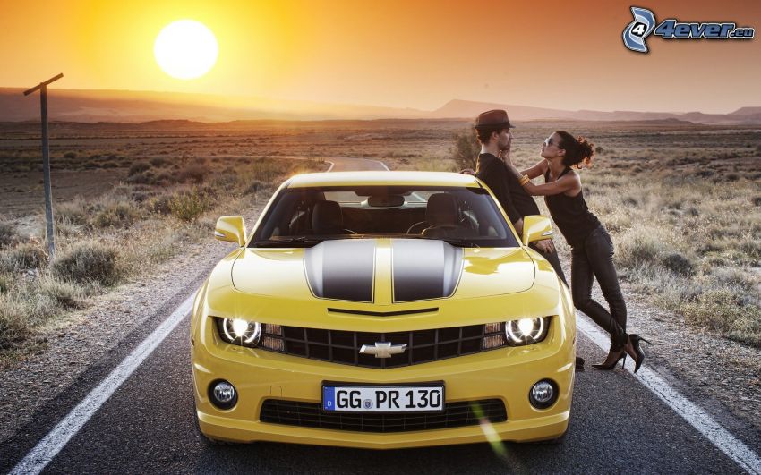 Chevrolet Camaro, predná maska, muž a žena, východ slnka, cesta