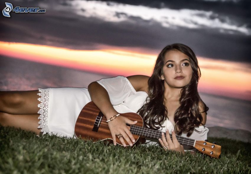 Isabela Moner, hra na mandolíne, tmavé oblaky, biele šaty