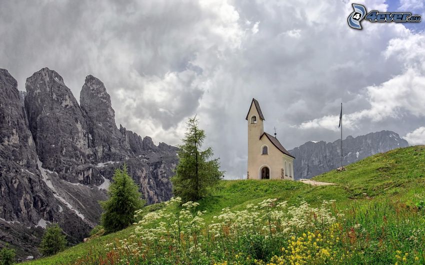 Dolomity, kostol, tmavé oblaky