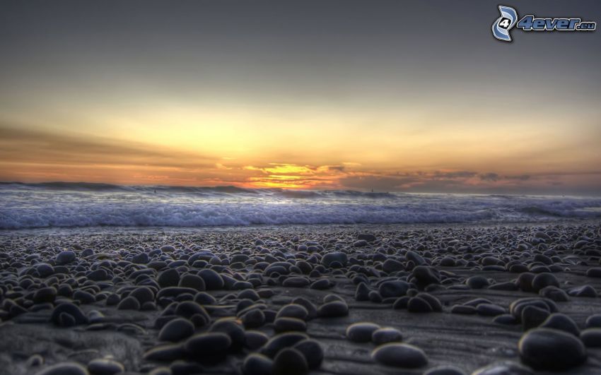 kamenná pláž, západ slnka za morom