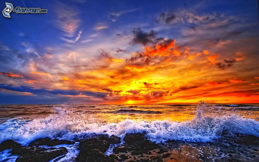 oranžový západ slnka nad morom, rozbúrené more