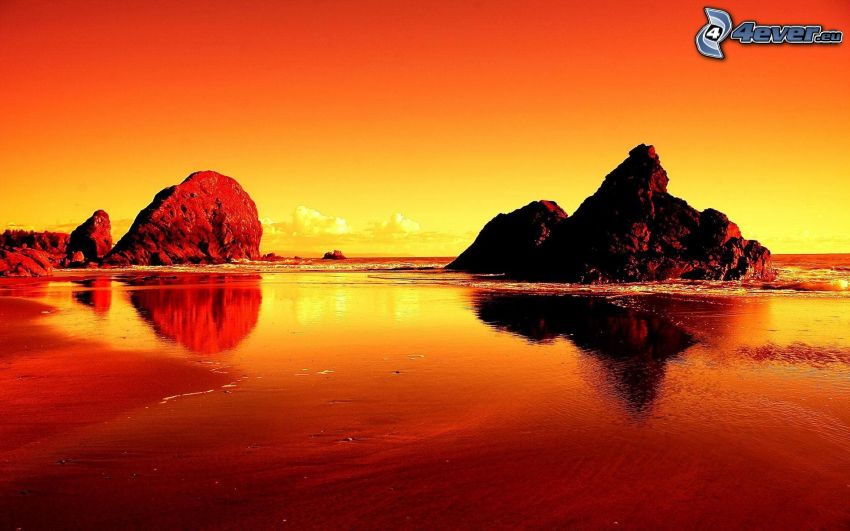 pláž pri západe slnka, skalnaté pobrežie, oranžový západ slnka