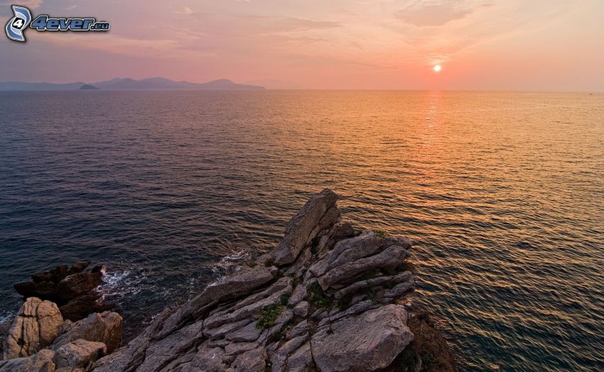 západ slnka nad morom, skaly v mori
