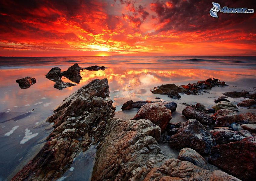 západ slnka za morom, skalnaté pobrežie, červená obloha