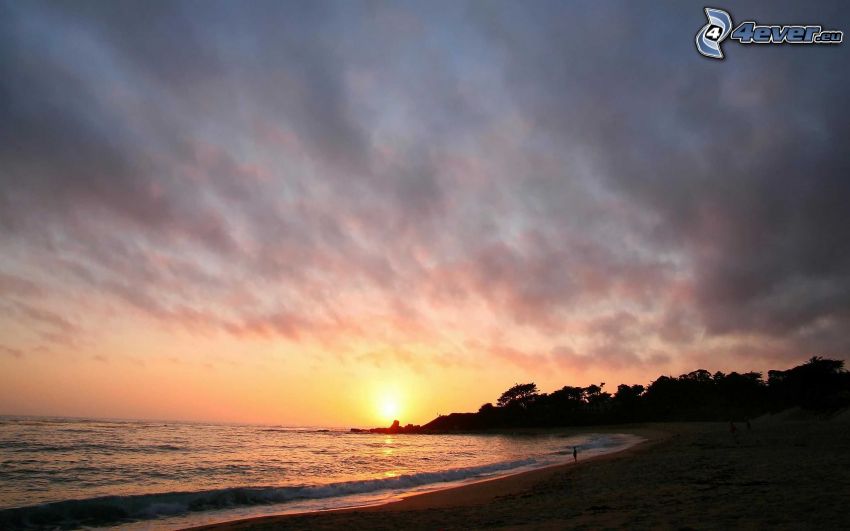 západ slnka za morom, večerná pláž