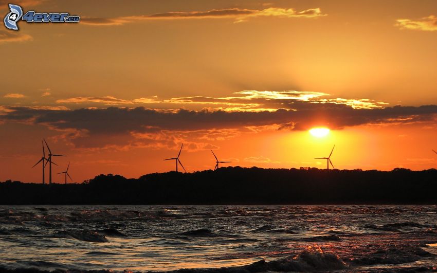veterné elektrárne pri západe slnka, more