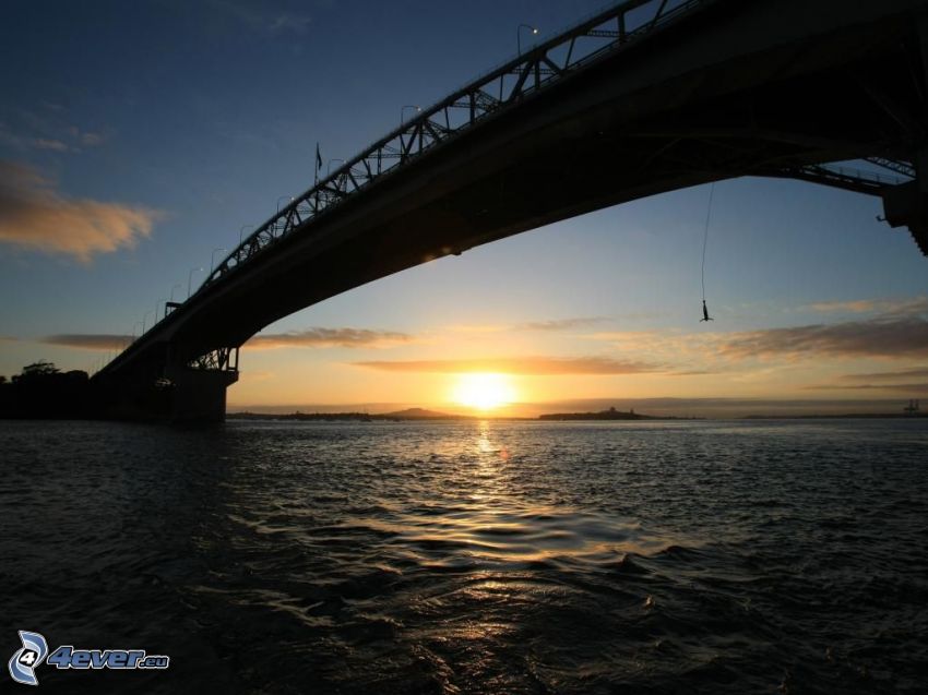 Auckland Harbour Bridge, západ slnka za morom