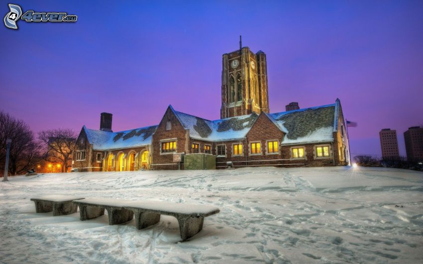 zasnežený kostol, veža, zasnežená lavička, stopy v snehu