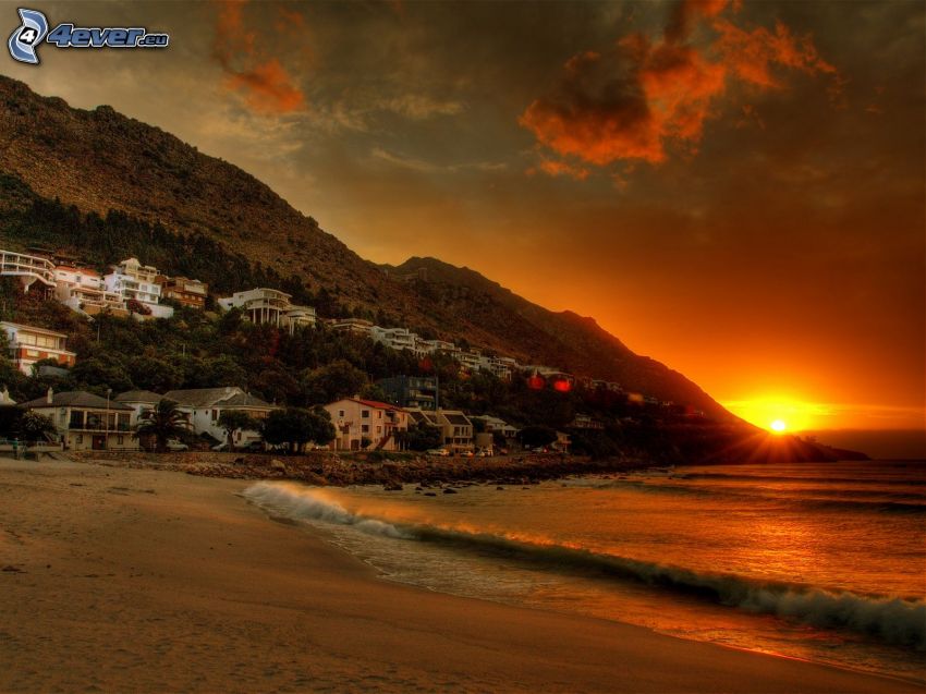 beach at sunset, houses, waves on the shore, sea
