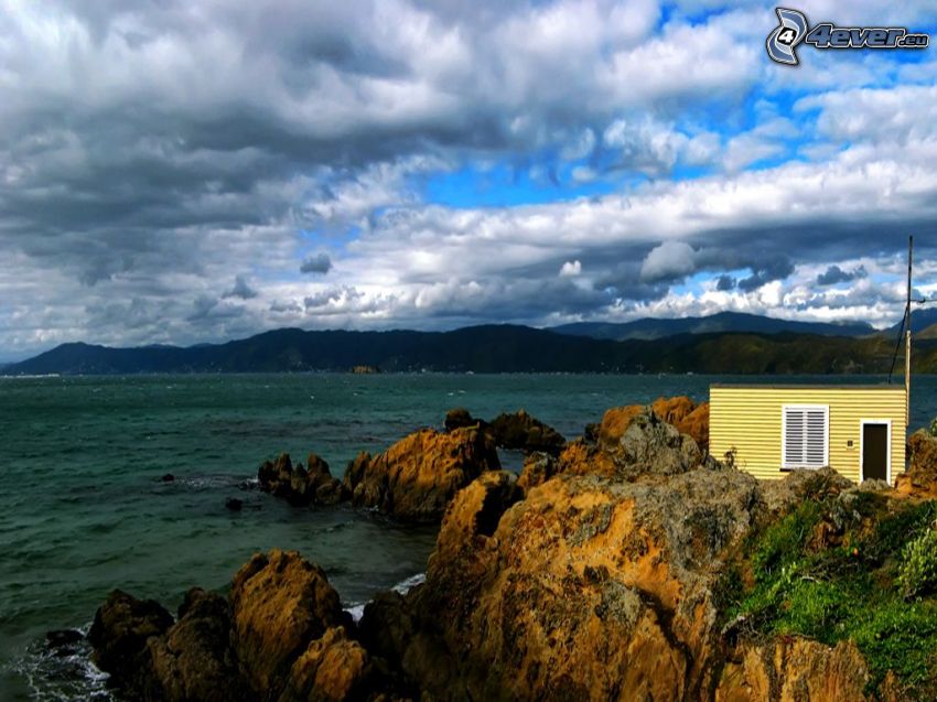 house on coast, rocks, clouds