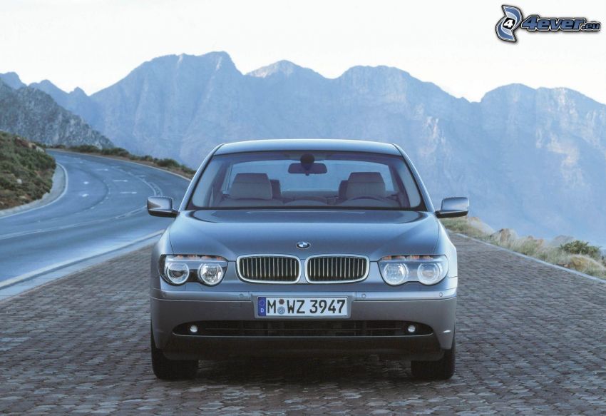 BMW 7, pavement, rocky hills