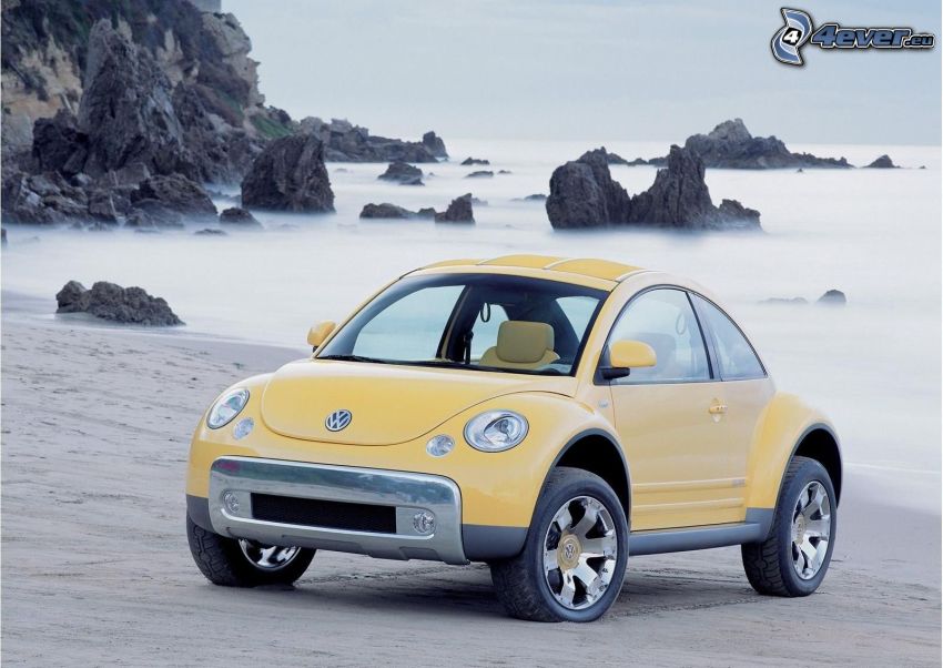 Volkswagen Beetle, sandy beach, rocks in the sea