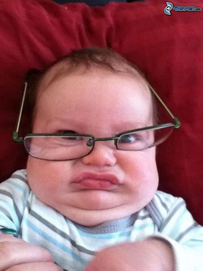 child with glasses, grimacing