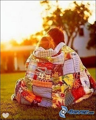 couple in embrace, blanket, park at sunset