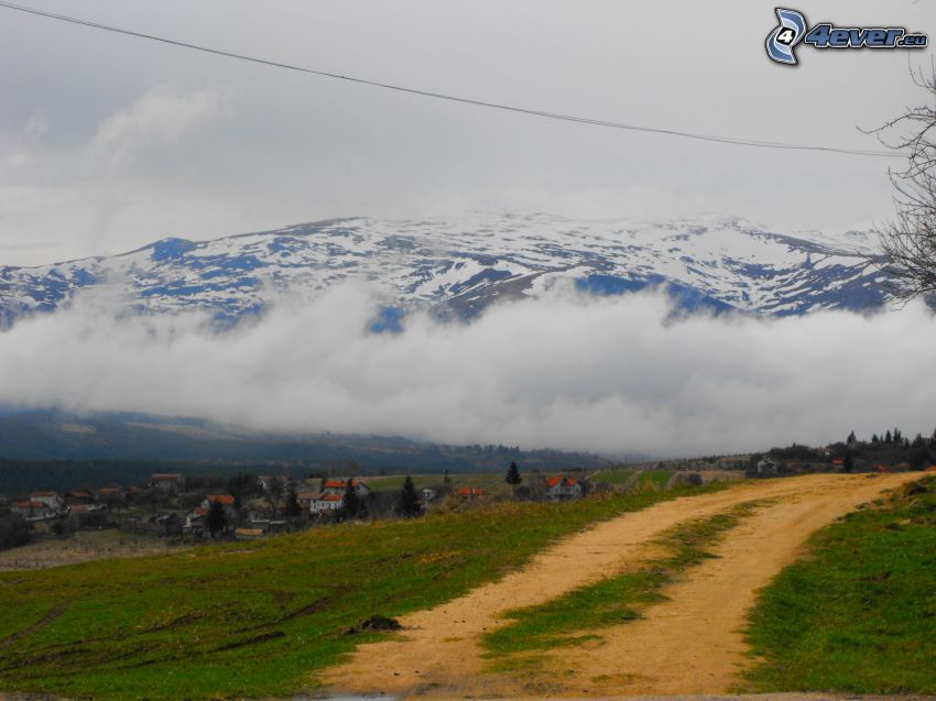 field path, clouds, snowy hills, village