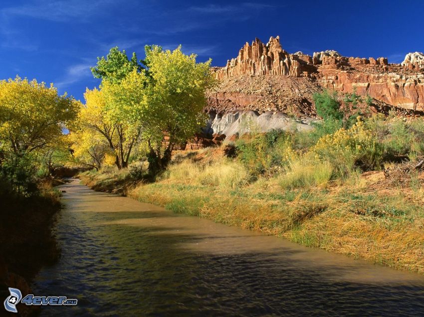 River, yellow trees, rocky hills