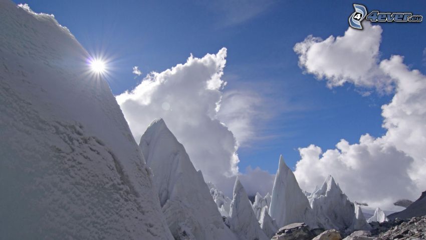 snowy mountains, clouds, sun