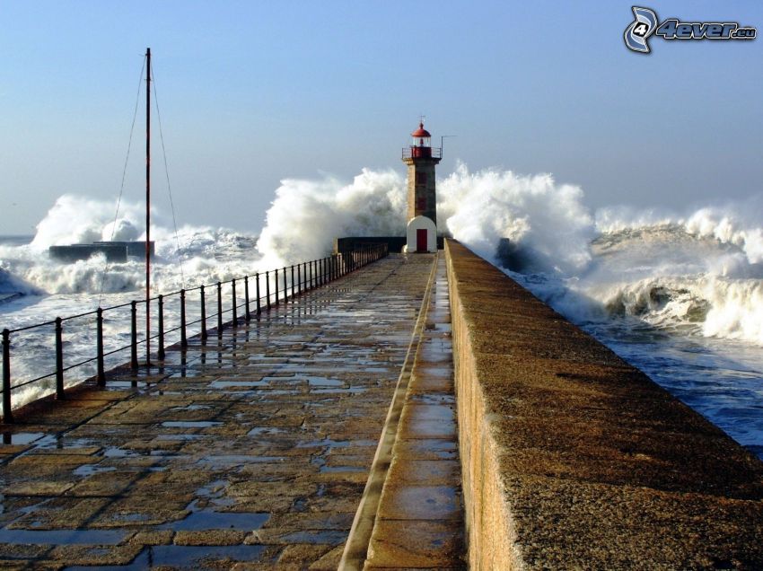 pier with a lighthouse, rough sea, waves on the shore