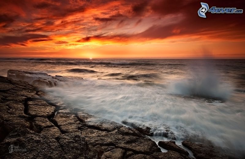 rocky shores, rough sea, orange sunset over the sea