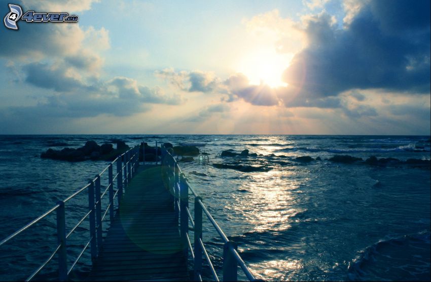 sea, wooden pier, sun behind the clouds