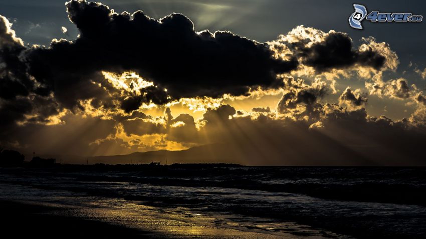 sunbeams behind clouds, sea