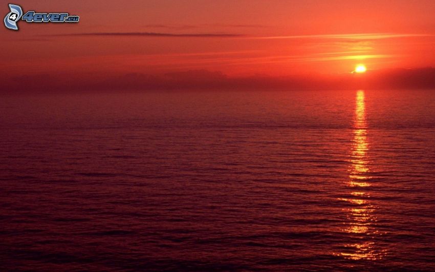 sunset behind the sea, red sky, reflection of the sun
