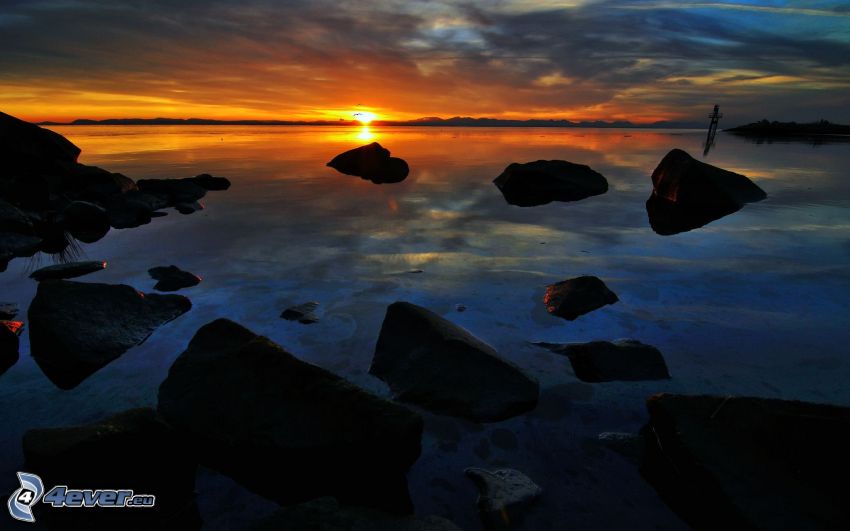 sunset behind the sea, rocks, dark sunset
