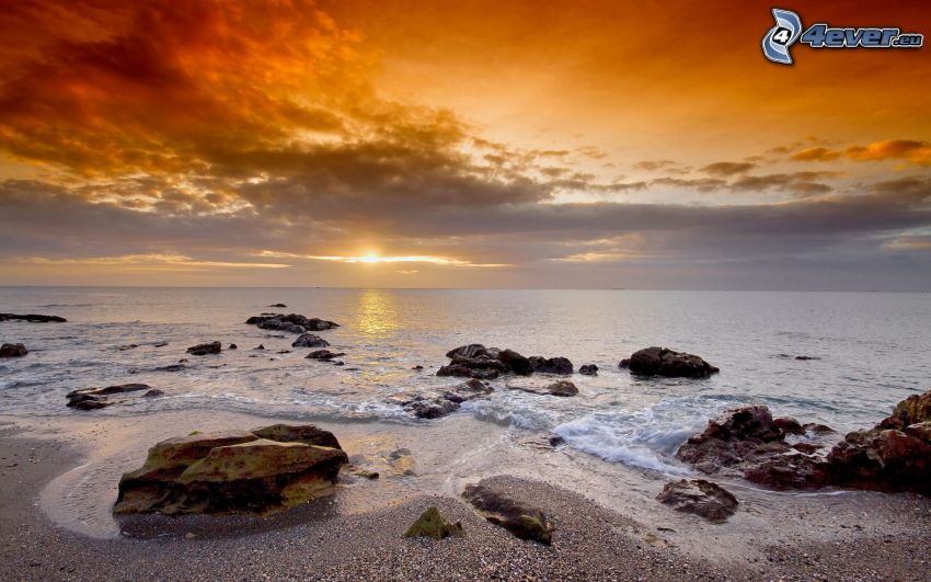 sunset behind the sea, rocky coast