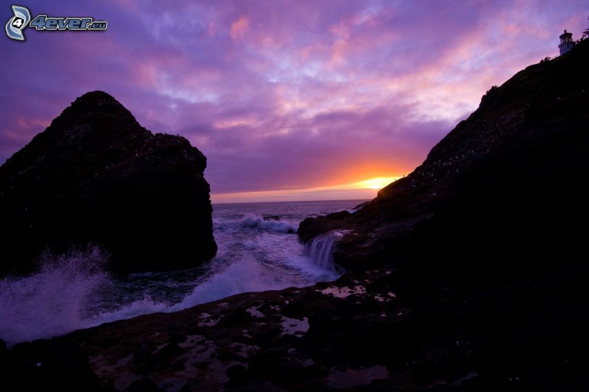sunset behind the sea, rocky shores, purple sky