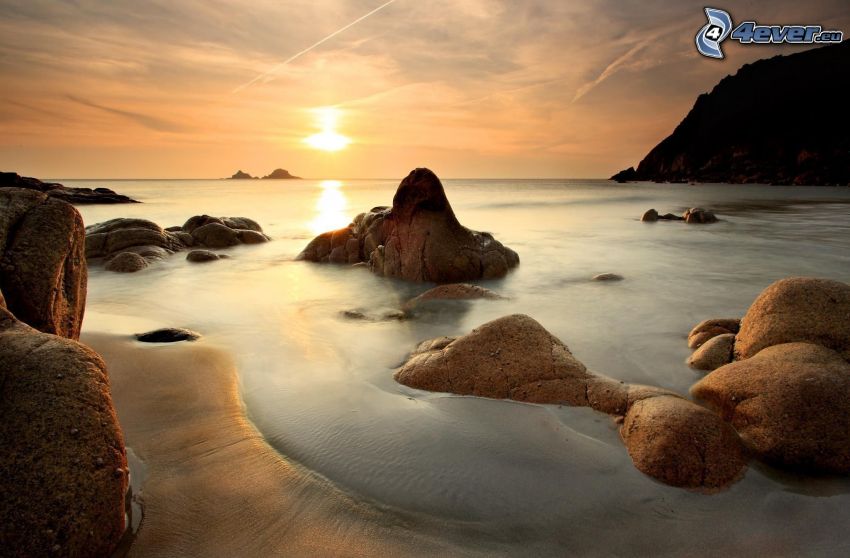 sunset behind the sea, rocky shores