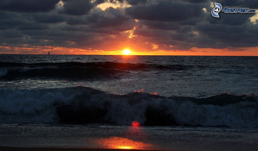 sunset behind the sea, wave, dark clouds