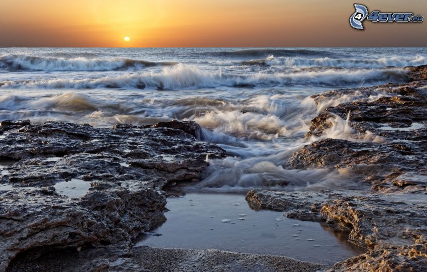 waves on the shore, sea, rocky shores, sunset behind the sea
