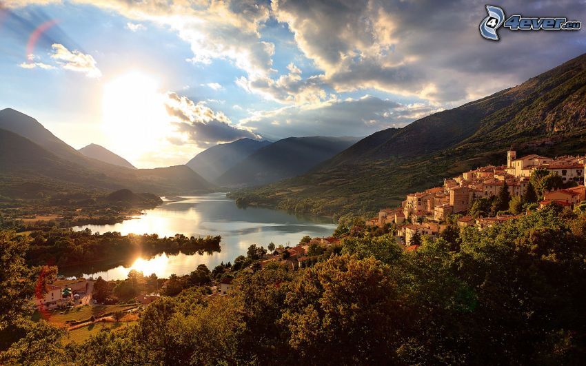 sun over lake, hills, houses, trees, view of the landscape