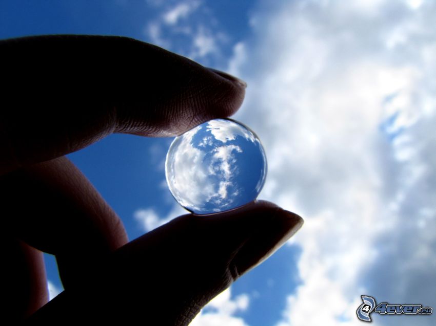 glass ball, clouds, fingers