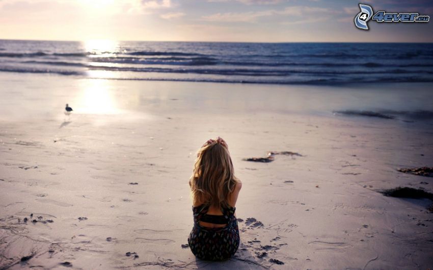 blonde on the beach, sunset behind the sea, sandy beach