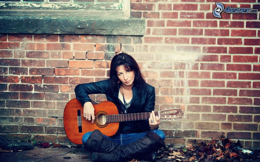 girl with guitar, brick wall