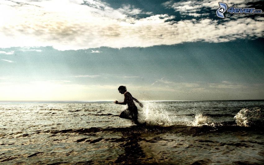 man in the sea, running, clouds