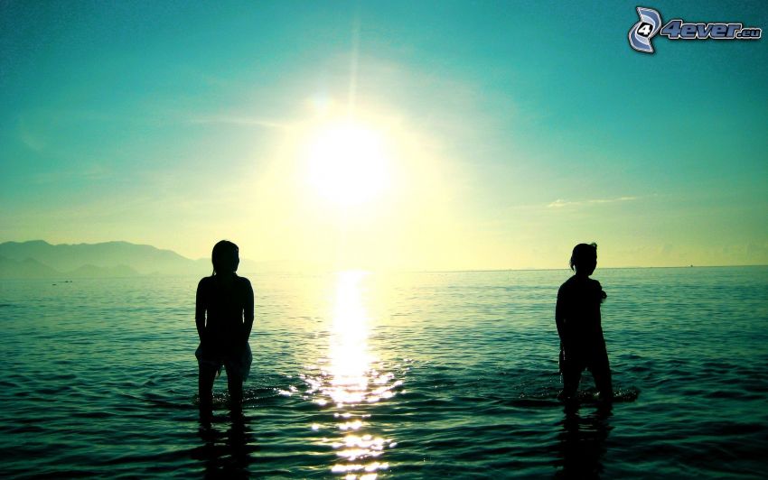 silhouettes of people, sea, sun