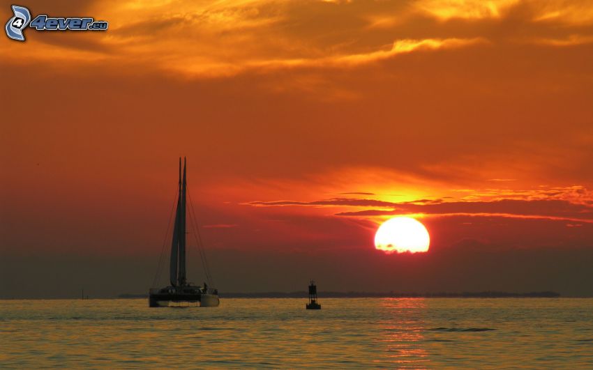 boat at sea, sunset behind the sea